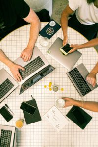 Tisch mit Karomuster auf dem Laptops und Handys liegen.