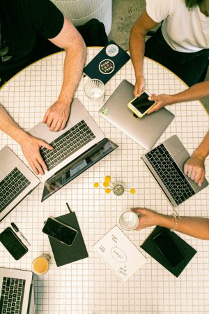 Tisch mit Karomuster auf dem Laptops und Handys liegen.